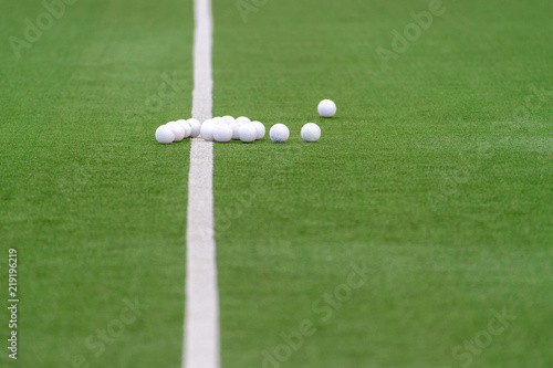 Green artificial grass hockey field with lines and balls photo