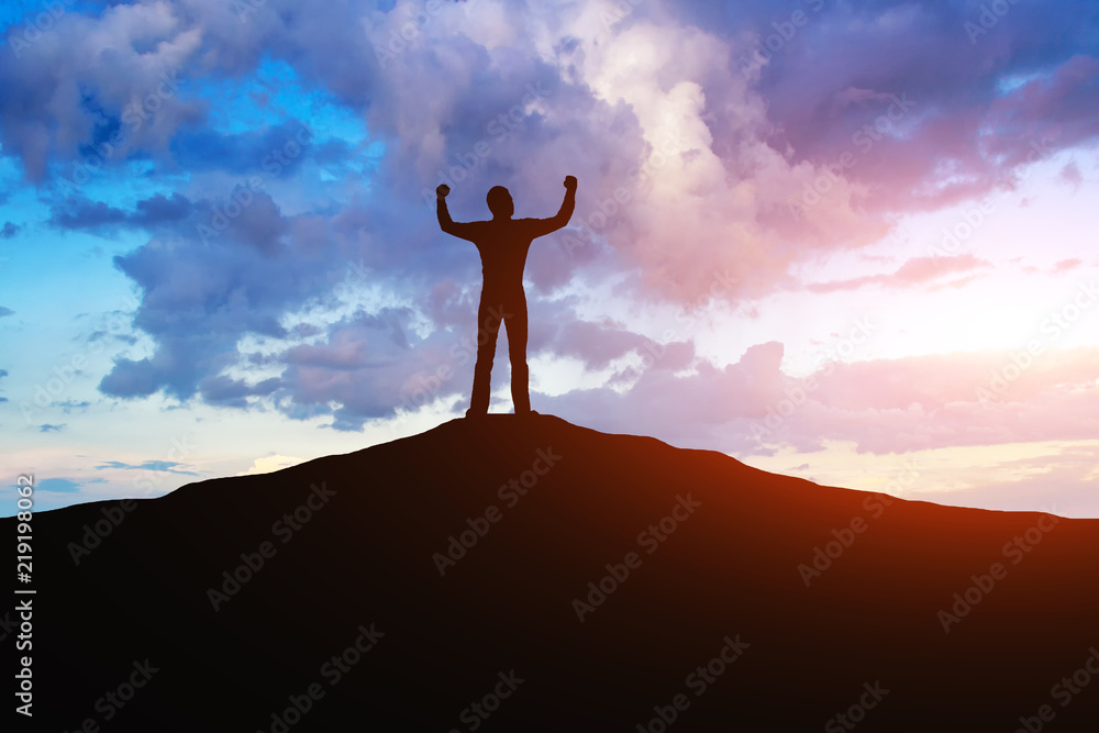Φωτογραφία Achieving success in a career, silhouette of a man on a mountain against a background of sunrise