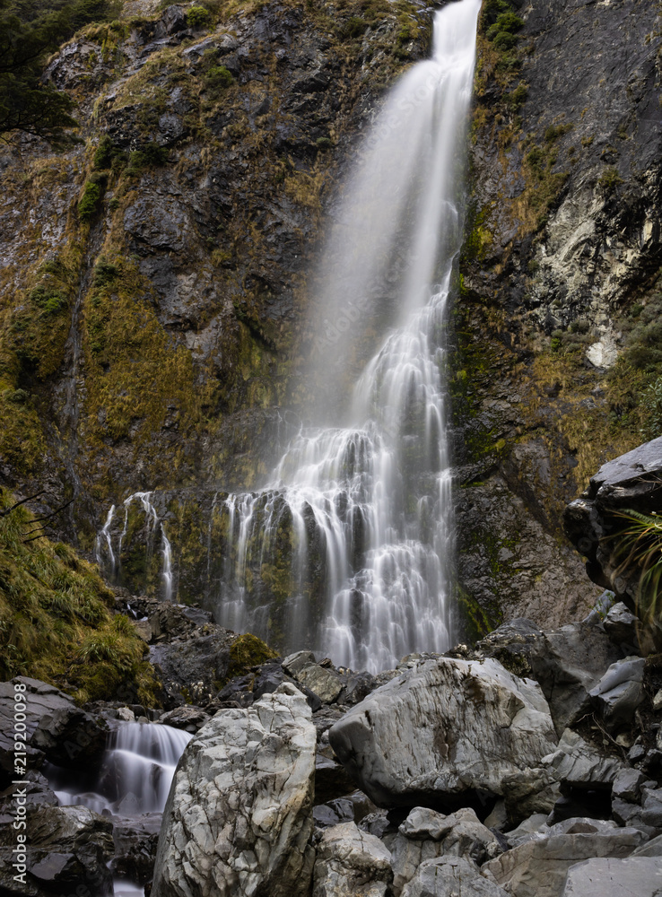 waterfall down mossy rockface