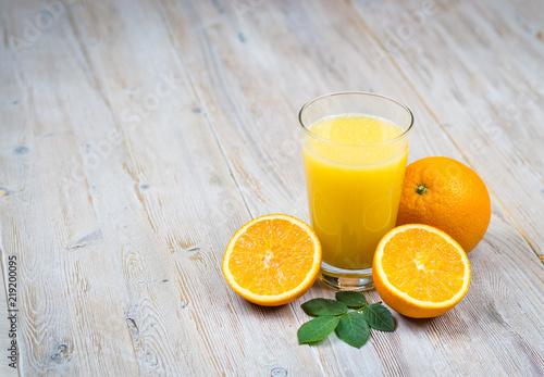 Orange juice and citrus fruits on rustic wooden table with copy space
