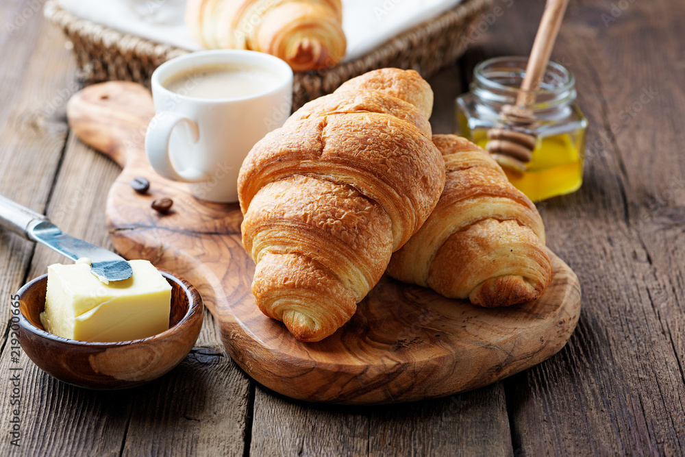 Delicious breakfast with fresh croissants and coffee served with butter and honey. - obrazy, fototapety, plakaty 