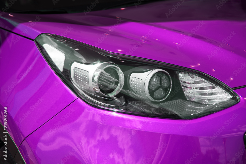 Modern headlight of a beautiful new car lilac. car light. glossy new car