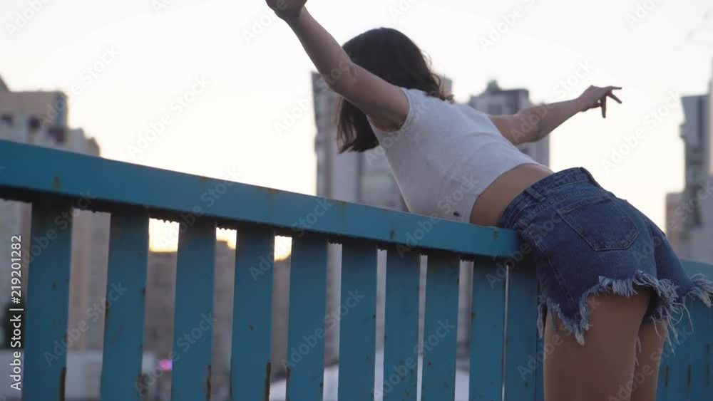 young nice teenage girl walking along the track. A brunette woman with a stitch. Attractive woman in stylish clothes. long female legs in the frame. 4K young nice teenage girl walking along the track. A brunette woman with a stitch. Attractive woman in stylish clothes. long female legs in the frame. 4K