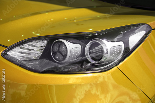 clean headlight. bumper of a new yellow car. car lamps. illumination of night roads.
