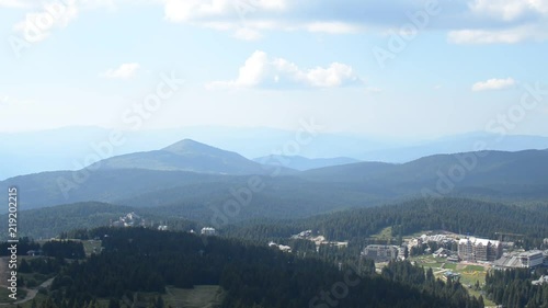Panning shot from the top of Kopaonik mountain, to the ski resort during summer. Camera stop moving briefly and after 6 seconds of pause, continue panning to the right.