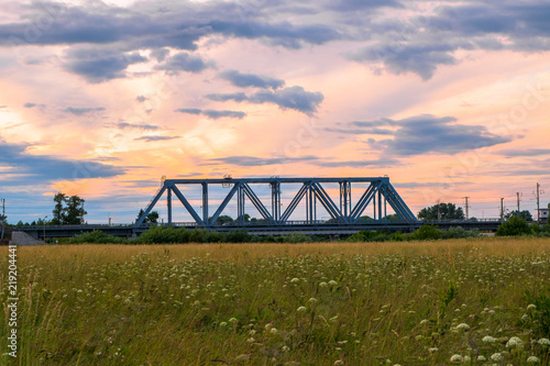 Evening sky over the railway bridge and flowered Bogolyubovo meadow, Vladimir region.