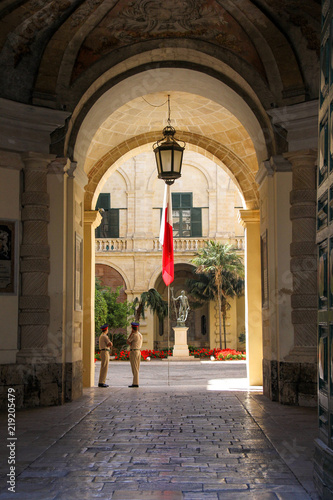 Photography View from arch entrance of Grandmaster Palace Courtyard with maltese flag and tw