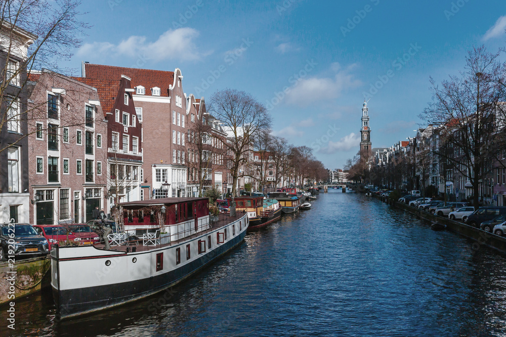 Obraz premium Boats and Houses along a Canal in Amsterdam, the Netherlands