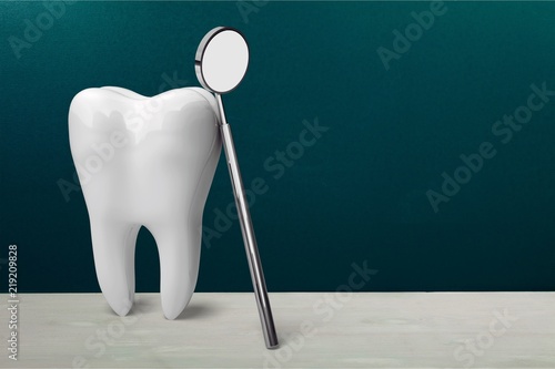 Big tooth and dentist mirror  medical concept