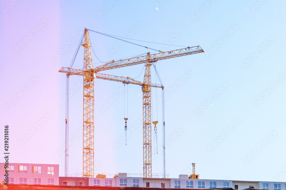 Building cranes and building under construction. Toned Building cranes and building under construction. Toned
