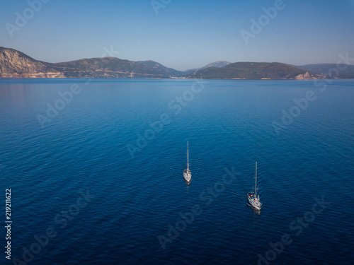 Aerial view to two Yachts in deep blue sea. Drone photography