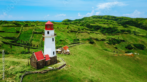 Drone shot of Mahatao Tayid Lighthouse on top rolling hills in the province of Batanes, Philippines
