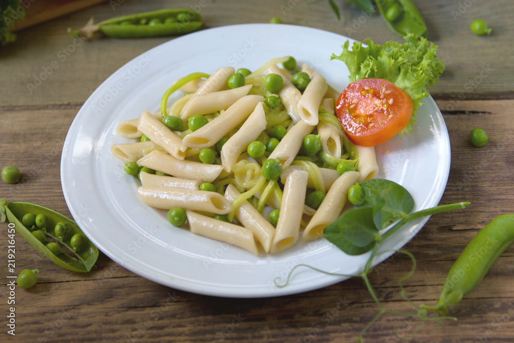 Penne pasta with green peas, zucchini noodle  and herbs