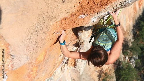 young woman rock climber climbing on the cliff. female climber climbing very hard route making hard moves and falling