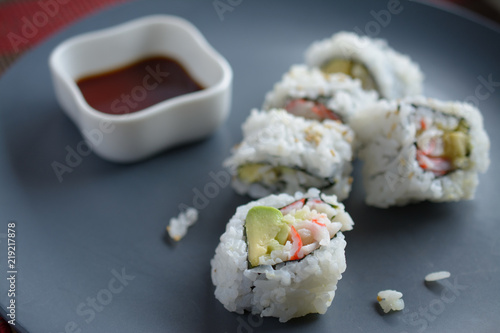 Maki on plate with cup of soy sauce
