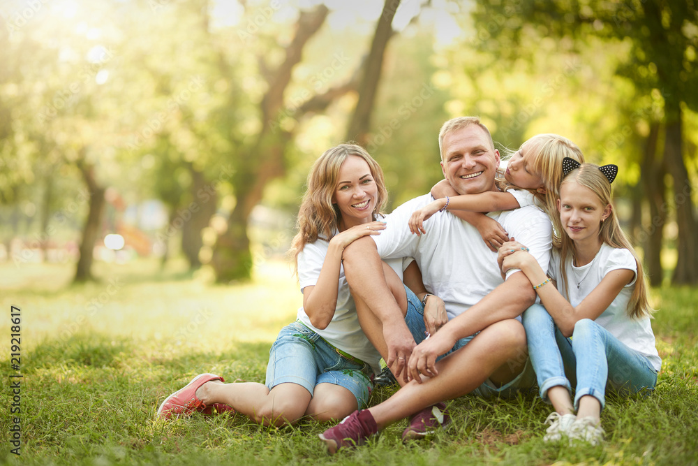 Cheerful family sitting on the grass during a picnic in the park