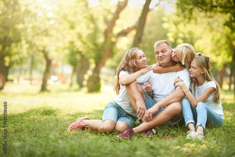Cheerful family sitting on the grass during a picnic in the park