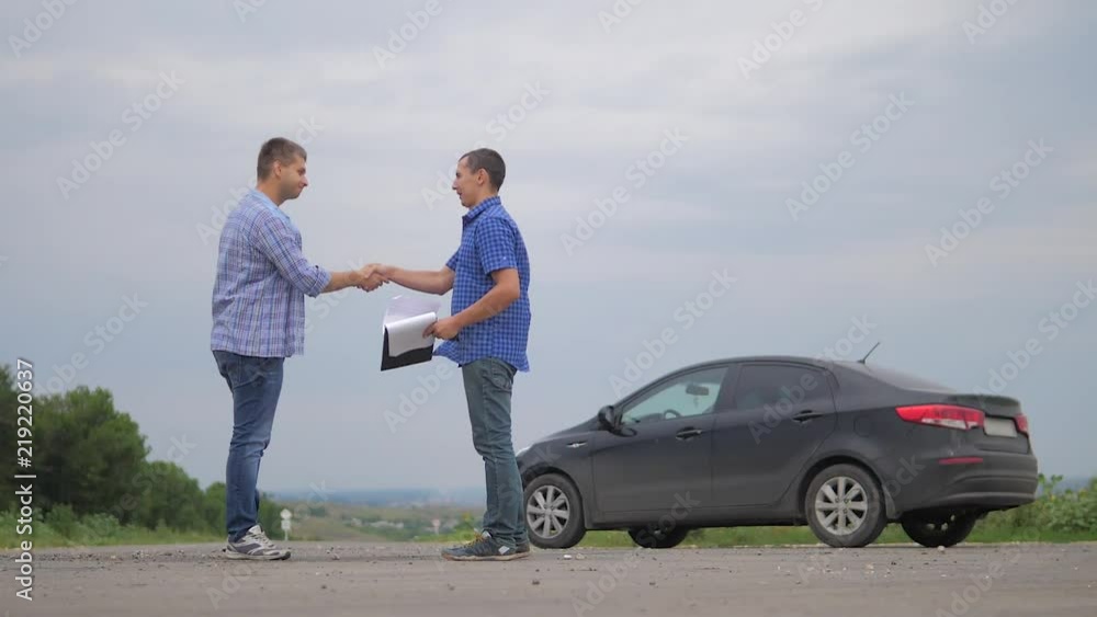 two men make deal. man handshake seller driver makes car the auto insurance slow motion video sale sells used cars. Buying rent a car . man car insurance sale of used cars concept. man test drive car two men make deal. man handshake seller driver makes car the auto insurance slow motion video sale sells used cars. Buying rent a car . man car insurance sale of used cars concept. man test drive car