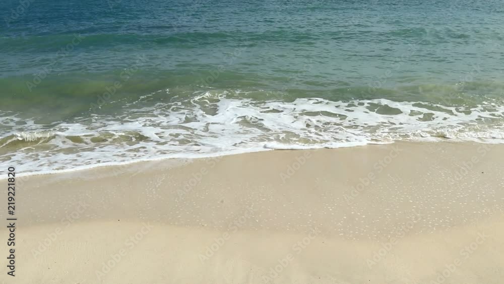Close up white soft wave rolling splash on empty tropical sandy beach in sunny day Close up white soft wave rolling splash on empty tropical sandy beach in sunny day