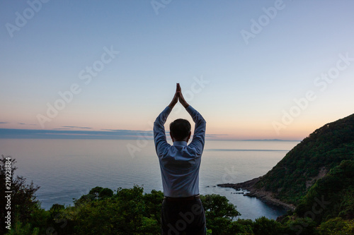 A man who poses in the sea before sunrise