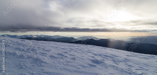 Winter alpine scenery with fresh snow, mist, and beautiful evening light