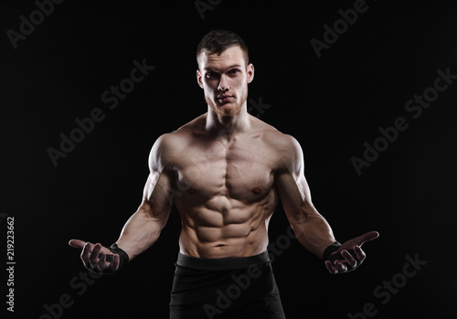 Aggressive man is a fighter, a bodybuilder on a black