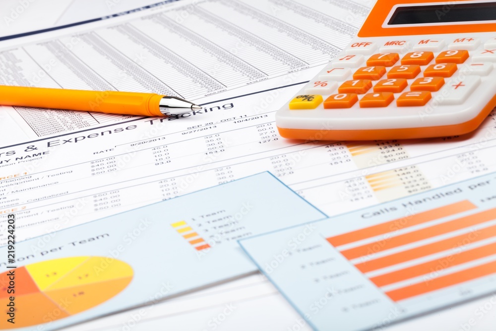Obraz premium Pen and Calculator on Business Graphs and Charts