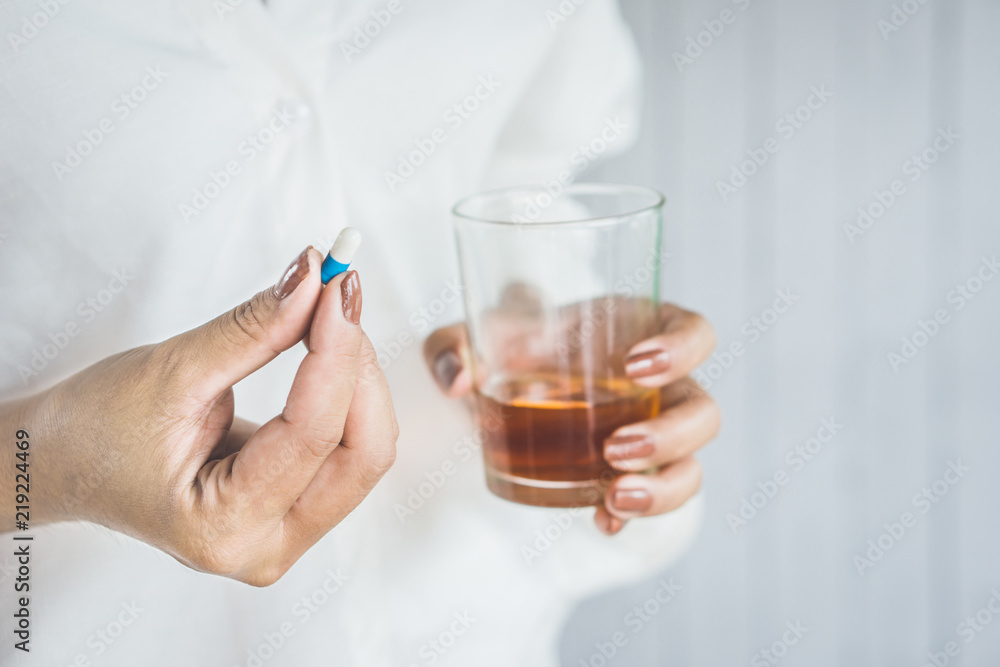 stress woman hand taking medicine with glass of alcohol, healthcare and medical concept background stress woman hand taking medicine with glass of alcohol, healthcare and medical concept background