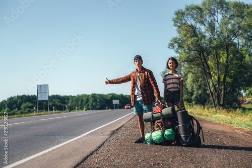 Hitchhiking couple. Backpackers on road