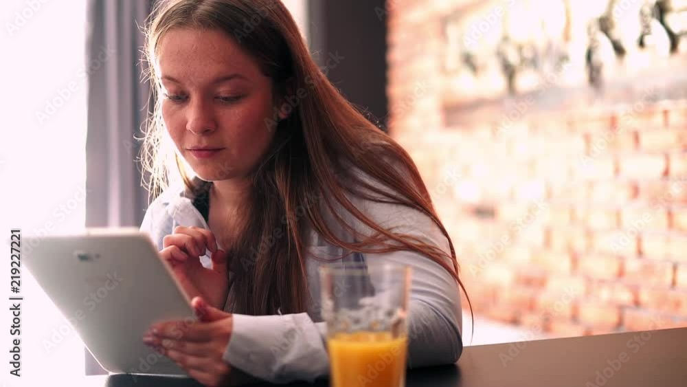 Pretty woman with tablet computer sitting by table at home
Pretty woman with tablet computer sitting by table at home