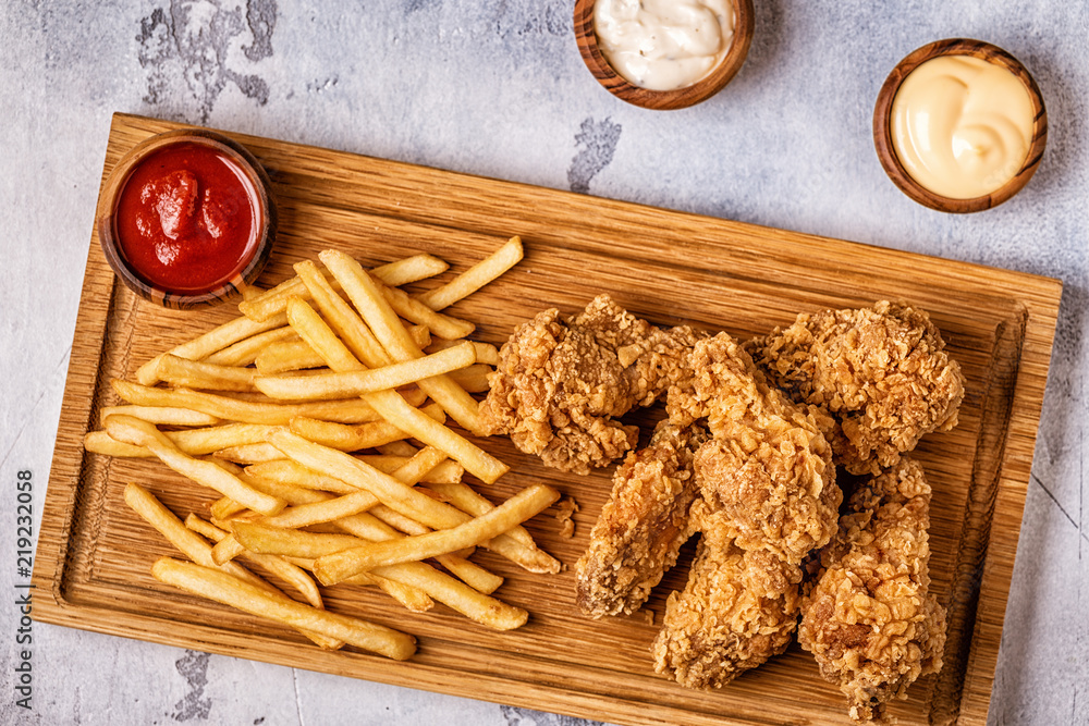 Naklejka premium Fried chicken wings with french fries.