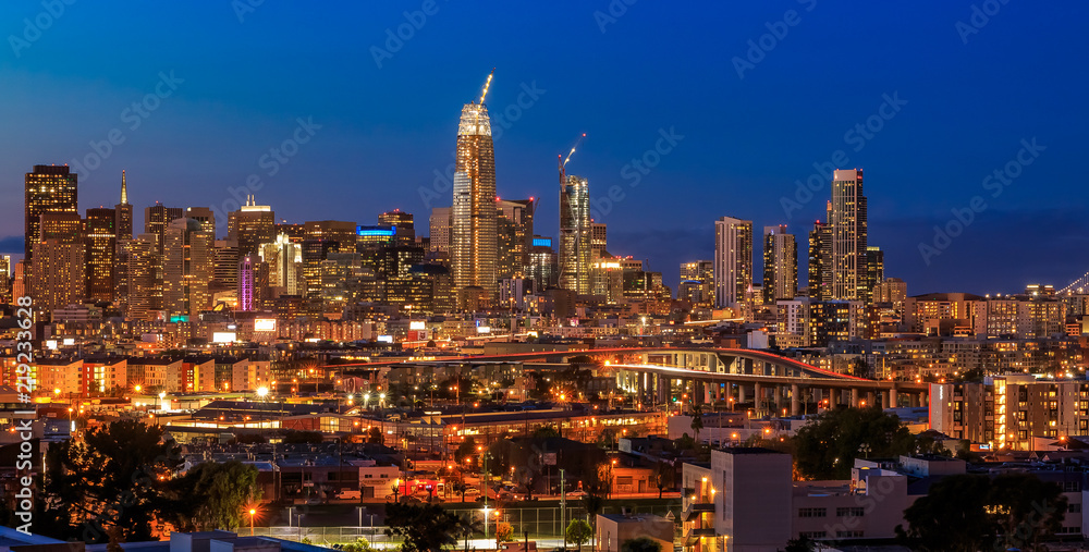 Naklejka premium San Francisco skyline panorama with city lights, the Bay Bridge and trail lights