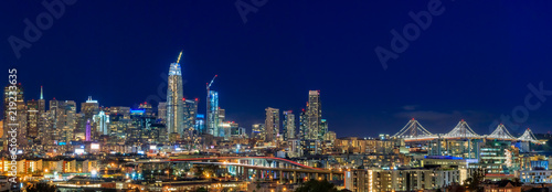 San Francisco skyline night panorama with city lights  the Bay Bridge and trail lights