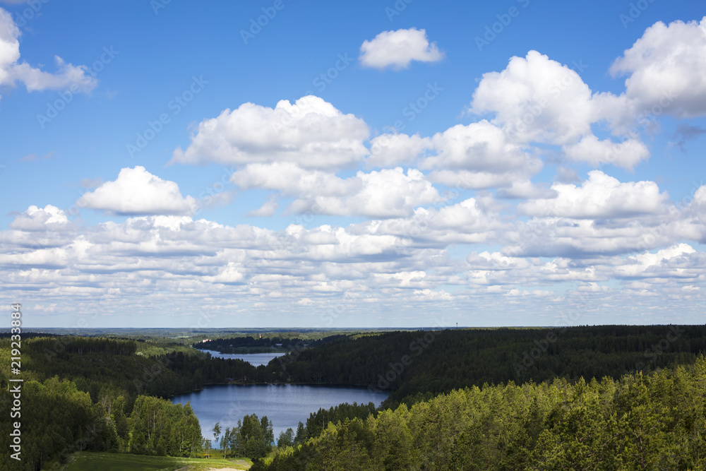 Landscape from Finland. The photo shows a blue sky and a lot of woods and lakes. It is summer and the sun shines.