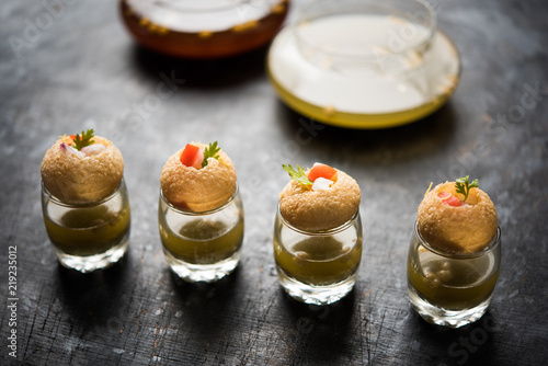 Fototapeta Naklejka Na Ścianę i Meble -  Pani Puri is an indian road side chat item - 4 stuffed puris kept over small glasses filled with mint water
