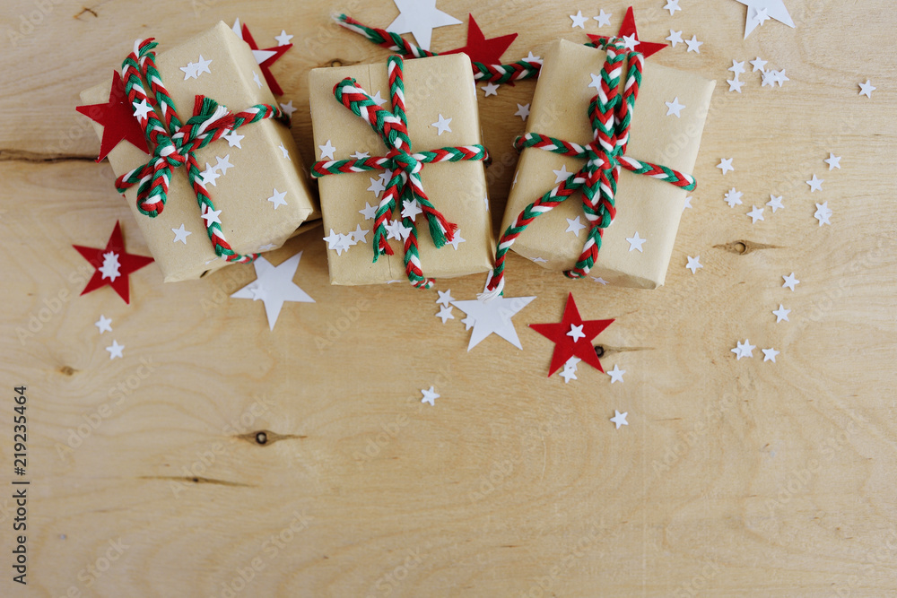 Christmas gifts in Kraft to packing on a wooden background Christmas gifts in Kraft to packing on a wooden background