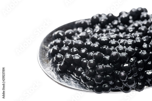 Spoon with black sturgeon caviar. Isolated white background photo