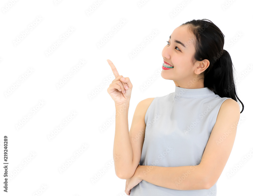 Portrait of Asian girl wearing dental braces smiling happily. Point to the separator isolated from white background. Portrait of Asian girl wearing dental braces smiling happily. Point to the separator isolated from white background.