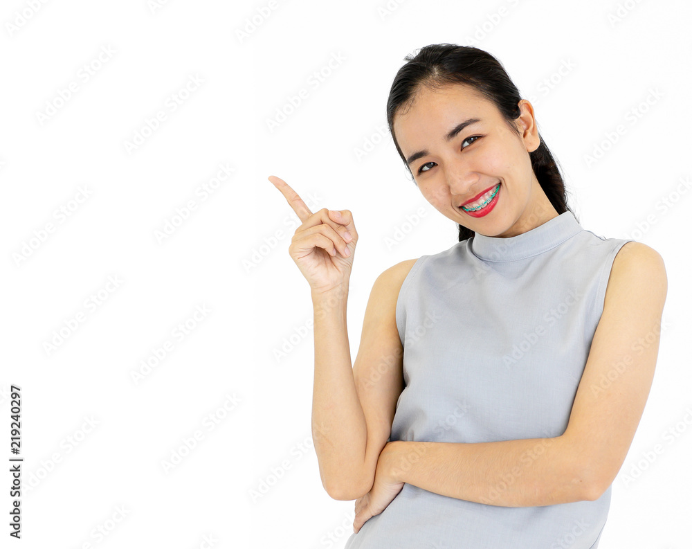 Portrait of Asian girl wearing dental braces smiling happily. Point to the separator isolated from white background. Portrait of Asian girl wearing dental braces smiling happily. Point to the separator isolated from white background.
