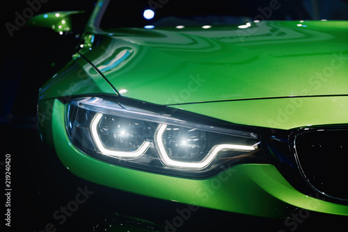 Fotografie Closeup headlights of modern car during turn on light in night.