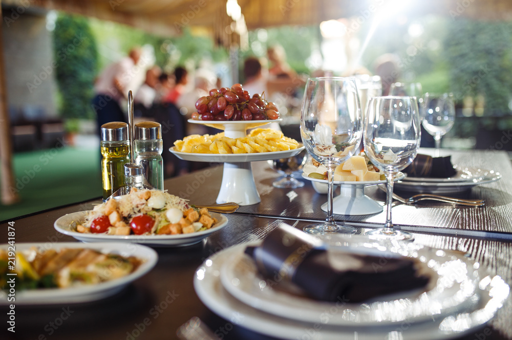 Sparkling glassware stands on long table prepared for wedding dinner