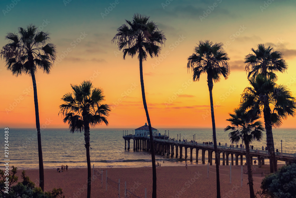 Obraz premium Kalifornijska plaża o zachodzie słońca, palmy i molo na Manhattan Beach w Kalifornii, Los Angeles. Przetworzone w stylu vintage.