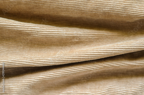 Texture of Soft Velvet Fabric with Folds Closeup. Texture of Beige Velvet Clothes. Textile Fabric of Corduroy as Background