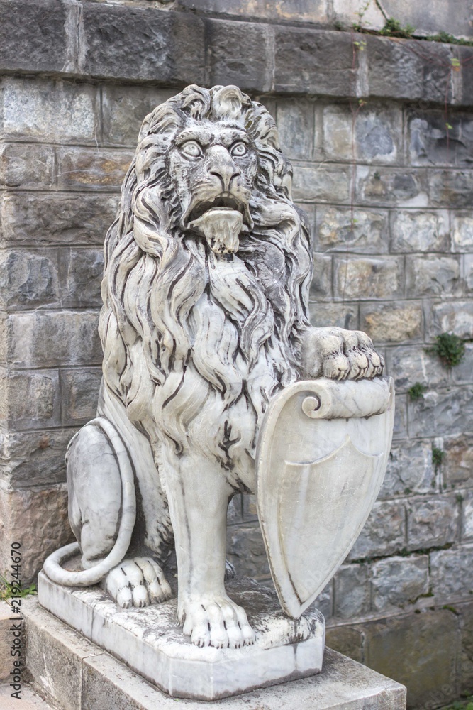 Marble sculpture. White stone lion. Architecture of the Middle Ages. European monuments. An ancient attraction. Peles Castle in Europe. Sculpture of an animal.