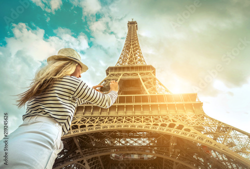 Woman tourist selfie near the Eiffel Tower in Paris under sunlight © Andrii IURLOV