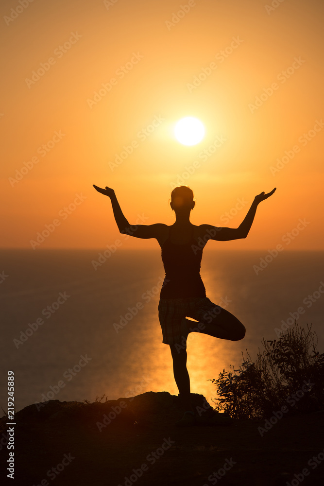 silhouette of a woman doing yoga during the sunset silhouette of a woman doing yoga during the sunset