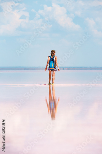 Girl stands by pink salt lake © Александра Голубцова