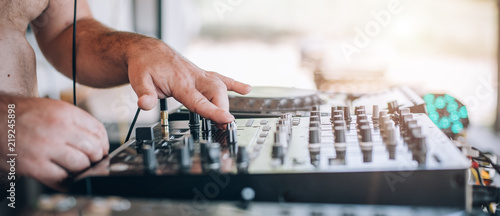 Closeup of DJ hands plays music on player and mixer