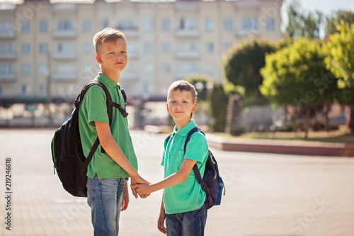 Two school kid boys with backpack on sunny day. Happy children go to school.