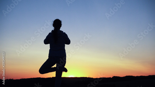 Fototapeta Naklejka Na Ścianę i Meble -  Silhouette young woman practicing yoga and Meditation at sunset
